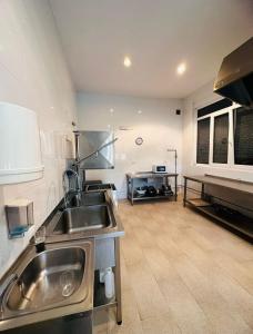 a kitchen with a stainless steel sink and a counter at Albergue de Guardo in Guardo