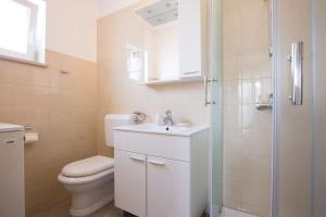 a bathroom with a toilet and a sink and a shower at Studio Ruzmarin in Krk +13 photos