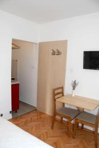 a room with a table and two chairs and a tv at Studio Ruzmarin in Krk