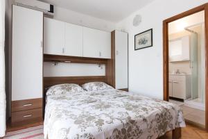 a bedroom with a bed and a mirror at Studio Ruzmarin in Krk