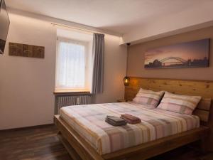 una camera con un grande letto con testiera in legno di Appartamento Litegosa a Panchia