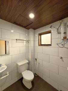 a bathroom with a toilet and a sink at Cool Point Hotel in Tanah Rata