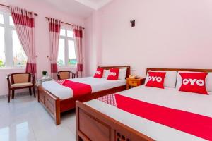 um quarto com 2 camas com almofadas vermelhas e brancas em Motel Tulip em Da Nang