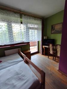 ein Schlafzimmer mit einem Bett und einem Schreibtisch mit einem Klavier in der Unterkunft Usługi hotelarskie Karpacz in Karpacz