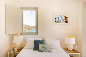 a bedroom with a bed with two lamps and a window at Cabana Seaview Pool Villas near Alemagou beach in Ftelia