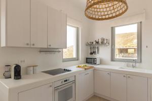 a white kitchen with white cabinets and a sink at Cabana Seaview Pool Villas near Alemagou beach in Ftelia