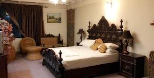 a bedroom with a large bed and a toilet at Undrah Inn Hotel in Rachiāl +3 photos