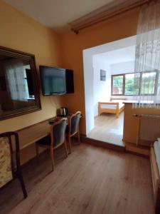 Zimmer mit einem Schreibtisch mit Stühlen und einem TV in der Unterkunft Usługi hotelarskie Karpacz in Karpacz