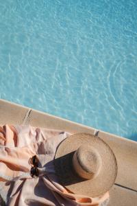 um chapéu de palha sentado ao lado de uma piscina em Villa d'exception vue mer avec piscine privée em Saint-Raphaël