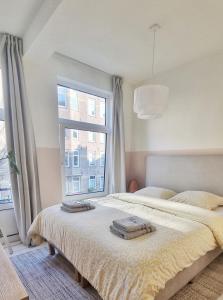 een slaapkamer met 2 bedden en een groot raam bij Cozy apparment close to center with big terrace in Amsterdam