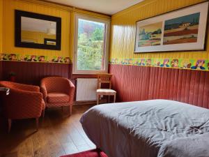 a bedroom with a bed and a chair and a window at Le reposoir in Mont-Saxonnex