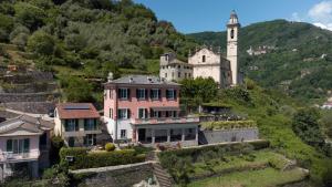 dom na wzgórzu z wieżą zegarową w obiekcie Rivarola al Tempo Dei Castelli w mieście Carasco