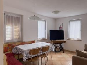 uma sala de estar com uma mesa e uma televisão em Appartamento Litegosa 2 em Panchia