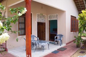 een huis met een tafel en stoelen op de veranda bij Sagopearl Guest in Mirissa