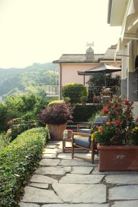 uma passagem de pedra com cadeiras e plantas numa casa em Rivarola al Tempo Dei Castelli em Carasco