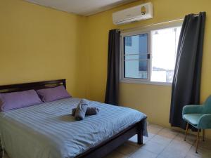 a bedroom with a bed and a window at Darin's Place in Prachuap Khiri Khan