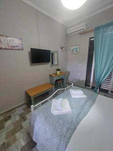 Habitación con mesa, TV y toallas. en Antzela Apartments en Sidárion