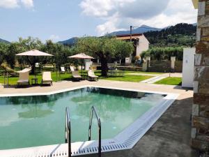 una gran piscina con sillas y sombrillas en Luminous Luxury Apartments, en Limenas