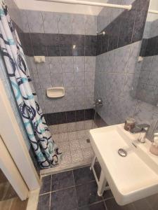 y baño con ducha y lavamanos. en Antzela Apartments en Sidárion