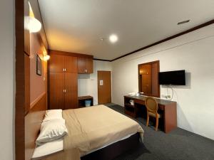 una camera d'albergo con un letto e una scrivania di Cool Point Hotel a Tanah Rata
