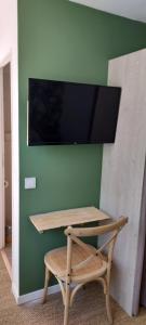 una scrivania con sedia e una TV a parete di Chambres d'hôtes Un Eté Sans Fin à 50 m de la plage à Canet plage a Canet-en-Roussillon