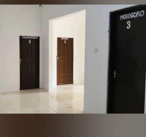 2 puertas marrones en una habitación con suelo de baldosa en BELLA VISTA homestay en Dimbani