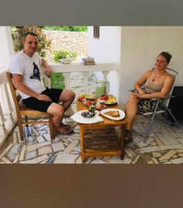 un hombre y una mujer sentados en sillas en un patio en BELLA VISTA homestay en Dimbani