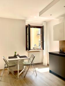 a kitchen with a table and chairs and a window at La Lum in Varallo