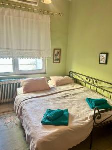 a bedroom with a large bed with two towels on it at Despina's House in Chrysoupolis