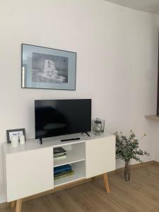 a white entertainment center with a flat screen tv at La Lum in Varallo +3 photos