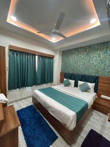 a bedroom with a bed and a green wall at Hotel Hill View in Gandhinagar