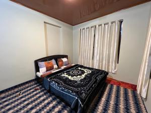 a bedroom with a bed and a window at GUREZ GUEST HOUSE in Kanzalwan