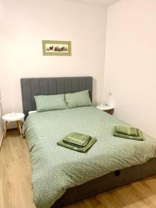 a bedroom with a bed with two green towels on it at La Lum in Varallo