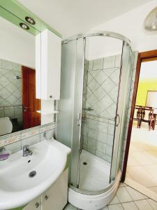 a bathroom with a glass shower and a sink at Summer apartments Shengjin in Shëngjin