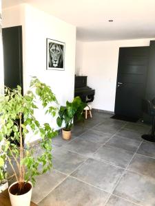 un salon avec des plantes en pot et un piano dans l'établissement House of SPA Courseulles Sur Mer, à Courseulles-sur-Mer