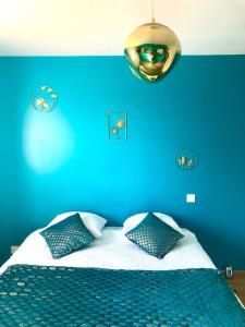 une chambre bleue avec un lit avec un mur bleu dans l'établissement House of SPA Courseulles Sur Mer, à Courseulles-sur-Mer 9 autres photos
