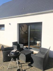 un patio avec des chaises et une table et une grande fenêtre dans l'établissement House of SPA Courseulles Sur Mer, à Courseulles-sur-Mer