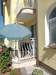 a blue umbrella sitting on a railing on a house at Ana Rooms in Krk