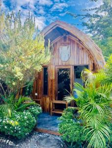 uma cabana de madeira com uma grande porta numa floresta em MAAYONG HOSTEL em Moalboal