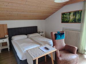 布魯尼科的住宿－Garni Hattlerhof B&B，卧室配有1张床、1张桌子和1把椅子