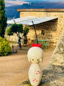 a figurine of a woman sitting on a wall at Au Petit Bonheur chez Bambina in Leynes