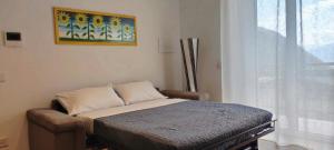 a small bed in a room with a window at APPARTAMENTO LA FUCINA in Molina di Ledro +25 photos