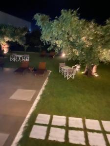 a garden with a table and chairs at night at Luminous Luxury Apartments in Limenas