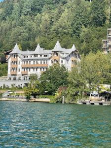 a large building on the shore of a body of water at Seehotel Bellevue in Zell am See