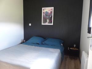 une chambre avec un lit et un tableau au mur dans l'établissement Cottage du Lac, à Olonzac 5 autres photos