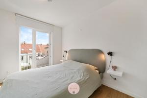 Habitación blanca con cama y ventana en BLOSS.II, en Ostende