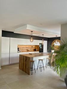 une cuisine avec des placards blancs et un îlot avec des tabourets de bar dans l'établissement Villa récente Sanary,piscine, 3 chambres ,proche mer et centre-ville, à Sanary-sur-Mer