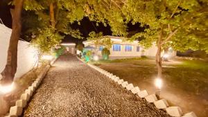 a house with lights in the yard at night at Hanaly Wood Resort & Cafe in Gilgit +7 photos