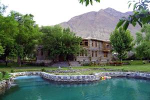 a building with a large pool of water in front of it at Hanaly Wood Resort & Cafe in Gilgit