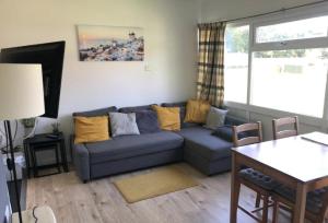 a living room with a blue couch and a table at Cosy Cabin - Bideford Bay Holiday Park in Bideford